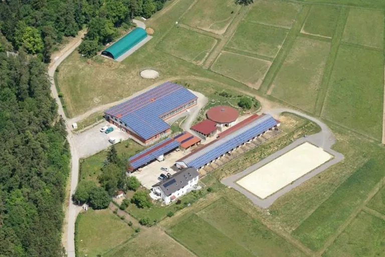 Luftbild des Barockreitzentrums Heimsheim mit Reithalle, Roundpen, Boxenreihen, Sandplatz und angrenzendem Wald